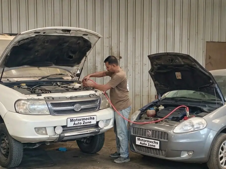 Mechanic jump-starting a car from another car with booster cables