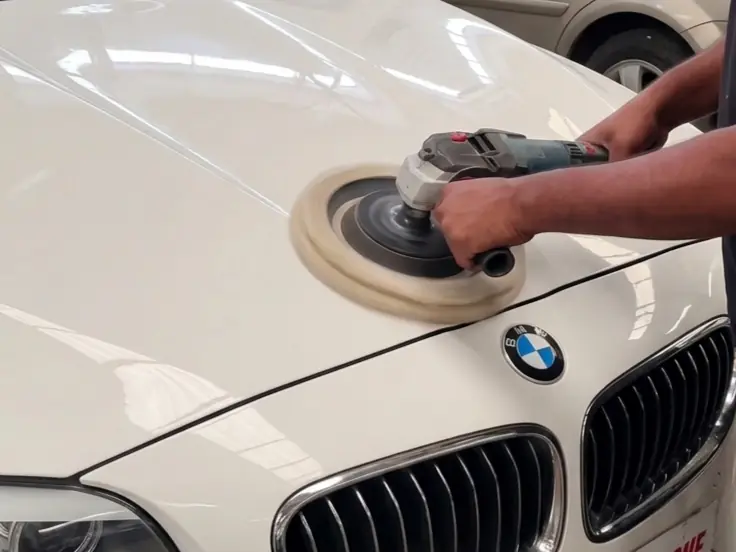 Machine polishing the bonnet of a white BMW