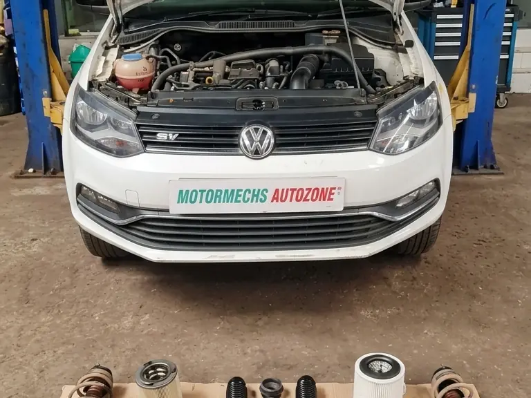 White Volkswagen Polo on a lift with the bonnet open