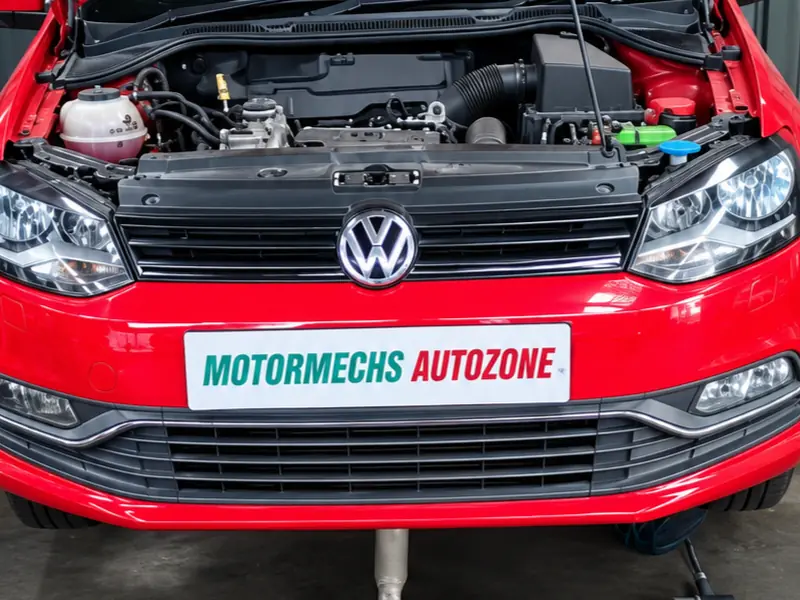 Red Volkswagen Polo with its steering rack and subframe removed for repair
